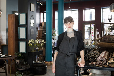 Portrait of confident young female owner standing at store