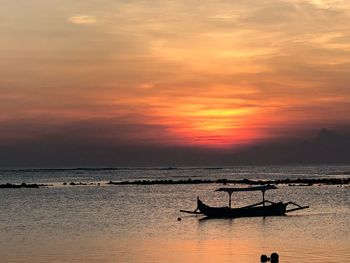 Silhouette boat in sea against sky during sunset