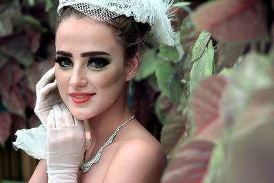 Portrait of beautiful bride standing by plants