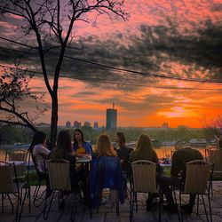 People sitting on chair at sunset