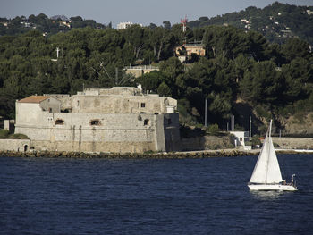 Scenic view of sea by buildings against sky