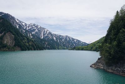 Scenic view of lake by mountains against sky