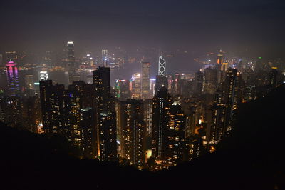 Illuminated cityscape against sky at night