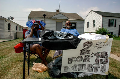 Man sitting in house against sky