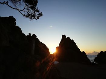 Silhouette rocks against sky during sunset