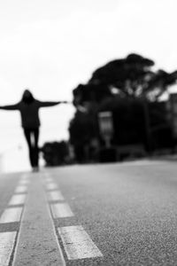 Rear view of person walking on road