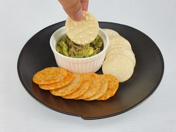 Close-up of hand holding food in plate