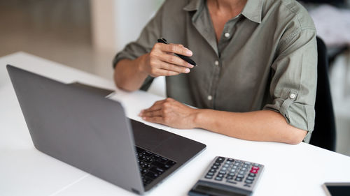 Midsection of businessman using laptop