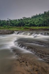 Scenic view of waterfall against clear sky