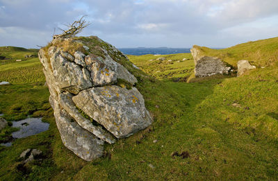 Rocks on field against sky