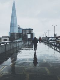 Rear view of silhouette man walking in city