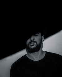 Portrait of man against black background