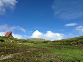 Scenic view of grassy field against cloudy sky