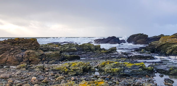 Scenic view of rocks in sea against sky