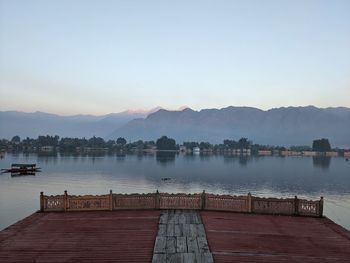 Pier over lake against sky during sunset