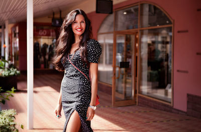 Beautiful young woman posing on street. fashion brunette model, wearing summer dress, accessories 