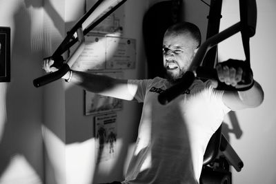 Man exercising while standing in gym