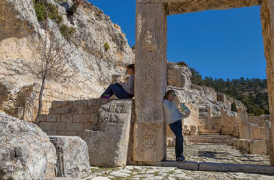 Friends by old ruins against mountain