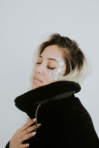 Portrait of a teenage girl looking away against white background