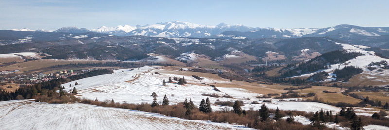 Aerial view on snowy valley during winter with massive mountain range in background slovakia, europe