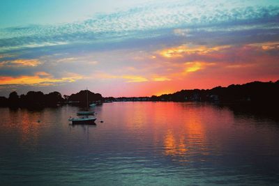 Silhouette boat in lake against sky during sunset