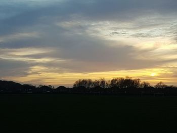 Silhouette of trees against dramatic sky