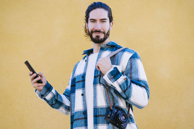 Portrait of young man holding smart phone