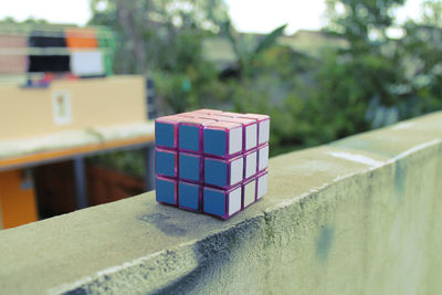 Close-up of puzzle cube on retaining wall
