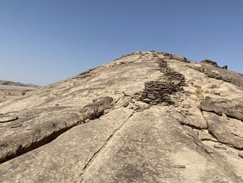 Low angle view of rock formation against clear blue sky