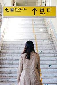 Rear view of woman standing on bus