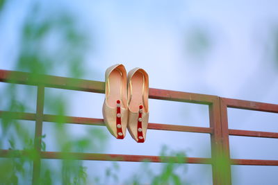 Low angle view of metallic fence against sky