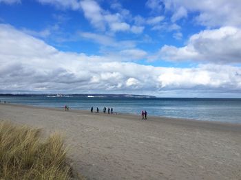 People at beach against sky