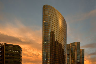 Low angle view of modern buildings against sky during sunset