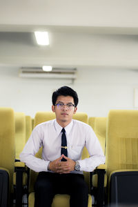 Portrait of young man sitting on chair