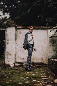 Full length of young man standing against trees