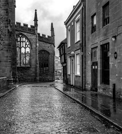 Wet road against sky in city