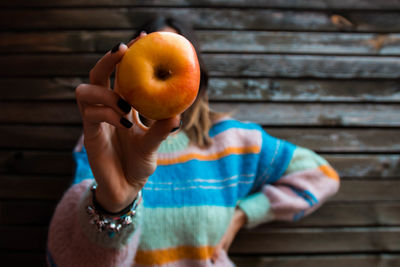 Midsection of woman holding apple