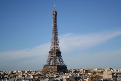 Eiffel tower amidst cityscape against sky