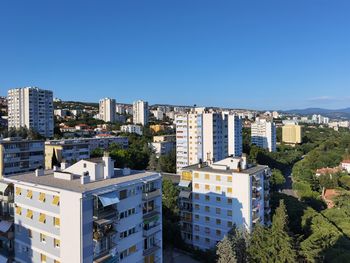 High angle view of buildings against blue sky