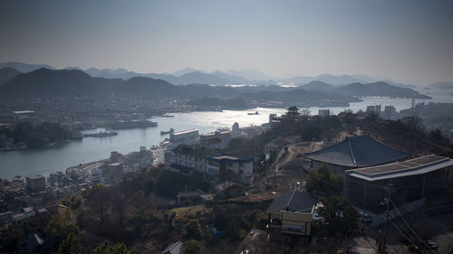 High angle view of townscape by sea against sky