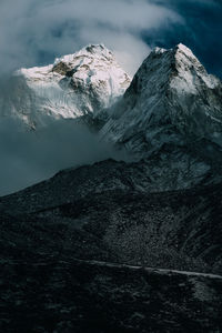 Majestic scenery of steep rocky mountains covered with clouds and fog in highlands