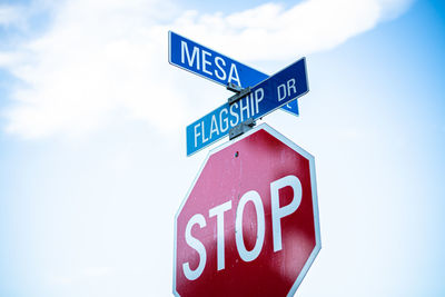 Low angle view of road sign against sky