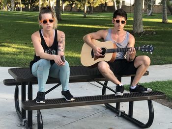 Portrait of young couple sitting on bench