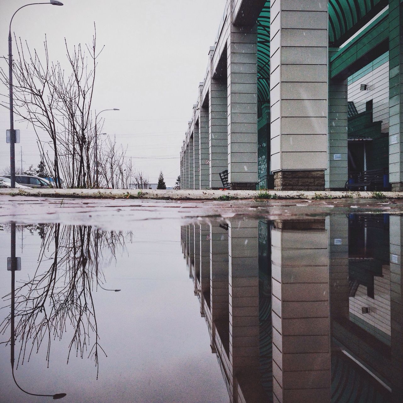 architecture, built structure, building exterior, reflection, water, waterfront, building, sky, canal, day, city, clear sky, no people, river, outdoors, railing, residential building, residential structure, connection, standing water