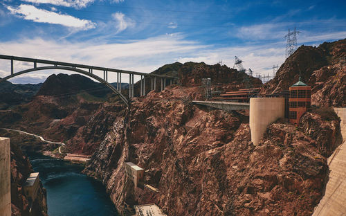 Bridge over river amidst buildings against sky