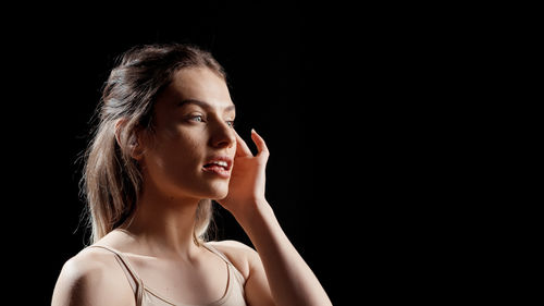 Young woman against black background