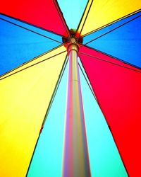 Low angle view of multi colored umbrella against blue sky