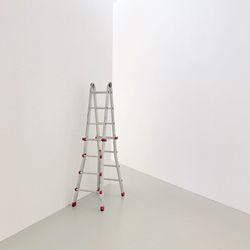 Step ladder by white wall on floor at home