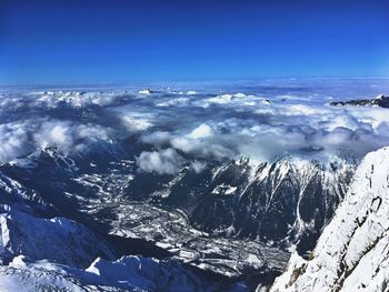 Scenic view of snowcapped mountains against blue sky