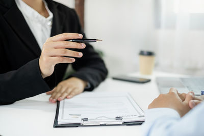 Midsection of business colleagues working on table